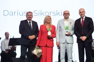 kobieta i trzej mężczyźni stoją w figurkami buraka cukrowego na scenie