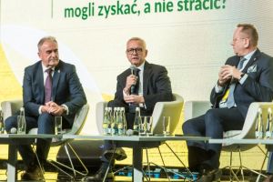 mężczyźni w garniturach siedzą na scenie