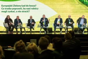 mężczyźni w garniturach siedzą na scenie